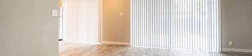 living room with wood look flooring and access to private patio/balcony with ceiling fan and vertical blinds