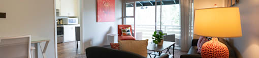 Living room view of furnished model apartment facing private patio/balcony