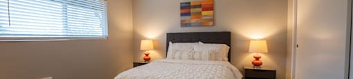 View of furnished model bedroom with carpet flooring and well lit window