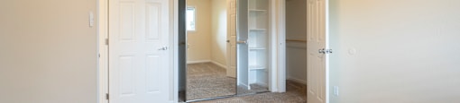 a bedroom with a ceiling fan and a closet with a mirrored door