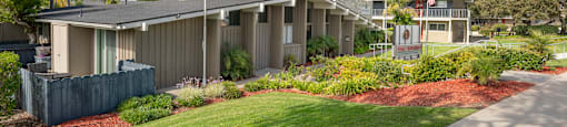 View of front office of The Diplomat with American flags flying high and lush landscaping