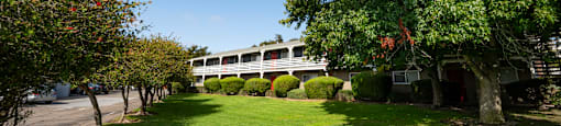 View of green space with building and trees in background