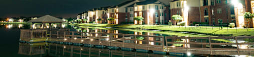 a row of apartments along a body of water at night