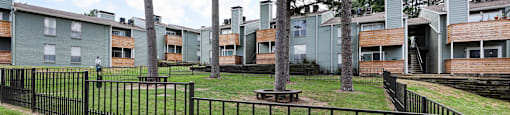 View of fenced dog park with building in the back ground
