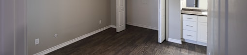 View of bedroom with bi-fold door closet, ceiling fan, and view of bathroom vanity