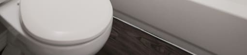 View of bathroom with tiled tub shower combo and toilet