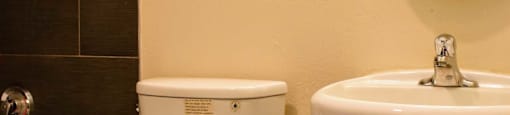 Bathroom featuring tiled tub shower combo, toilet, sink and mirror