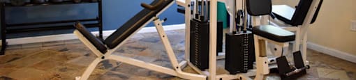 View of community gym with free weights, weight machine, and well lit window