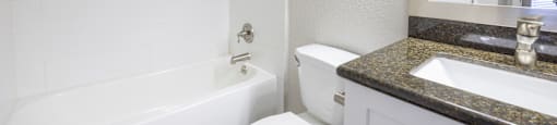a bathroom with a toilet and a tub and a sink