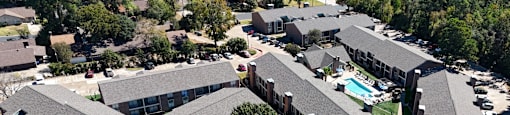 an aerial view of a building with cars parked in a parking lot