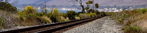 a train track with a mountain in the background
