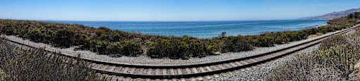 a stretch of train tracks with the ocean in the background