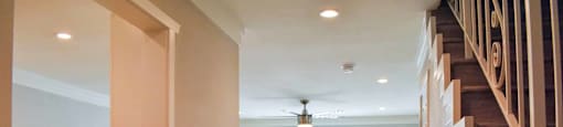 view into living room with wood look flooring, well lit window, and ceiling fan