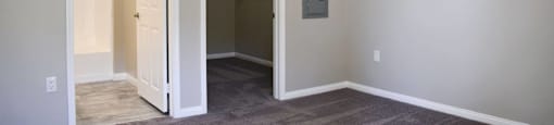 Bedroom looking into walk in closet and en suit bathroom. Has carpet flooring in bedroom and tile flooring in bathroom