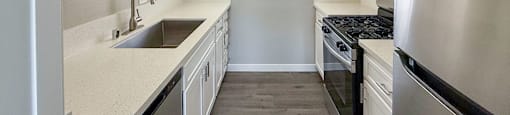 A modern kitchen with stainless steel appliances and white cabinets.