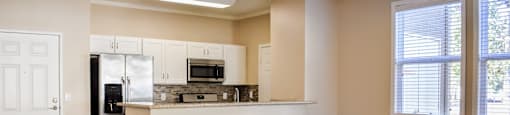 view from living room to kitchen with wood look flooring and well lit windows