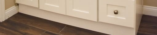bathroom with vessel sink, large mirror with lighting, medicine cabinet and white cabinets