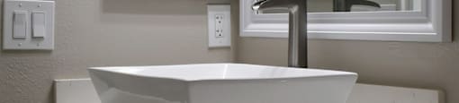 bathroom vanity with vessel sink, white cabinets, large mirror, and medicine cabinet