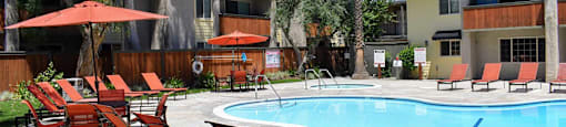 View from pool area with lounge chairs and seating area, and spa