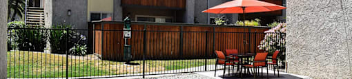 View from inside pool area facing exterior of buildings featuring private patio/balconies, and seating areas within pool
