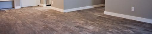 View of front entry with kitchen newar by featuring stainless appliances, tile back splash, wood like flooring and small sliding glass closet in entry way with built in shelving.