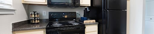 a kitchen with black appliances and white cabinets