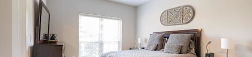 a bedroom with a bed and a dresser and a window
