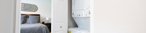 a small laundry room with a washer and dryer in a bedroom