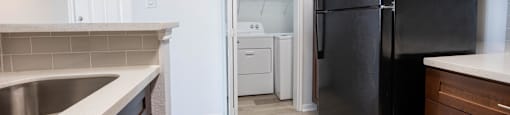 a kitchen with black appliances and a black refrigerator