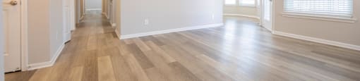 the living room and dining room of an empty house with wood flooring