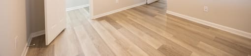 a living room with white walls and wood floors