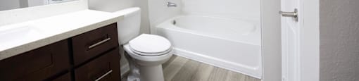 a bathroom with a toilet and a tub and a sink