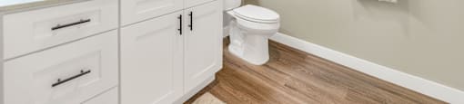 Bathroom with white cabinets and a toilet and a sink at Solace at Ballpark Village, Goodyear