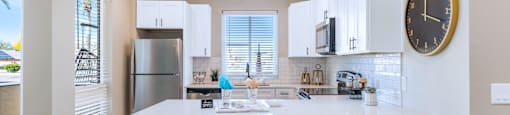 Large kitchen with stainless steel appliances and granite counter tops at Solace at Ballpark Village, Goodyear, AZ, 85338