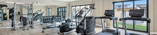 Spacious gym with treadmills, weights, and exercise equipment at Solace at Ballpark Village, Goodyear, AZ, Arizona