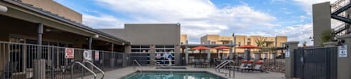 a swimming pool at a hotel with a blue cloudy sky at Inspiration Apartments, Cottonwood, Arizona