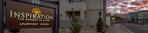 a sign in front of a building with a sunset behind it at Inspiration Apartments, Cottonwood, AZ, 86326