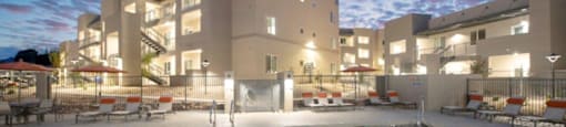 a swimming pool with palm trees in front of a building at Inspiration Apartments, Cottonwood