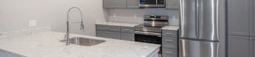 a kitchen with stainless steel appliances and a marble counter top at Inspiration Apartments, Cottonwood, 86326