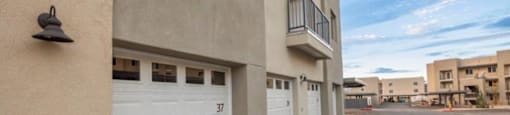 an empty parking lot with a building with white garage doors at Inspiration Apartments, Cottonwood, AZ, 86326