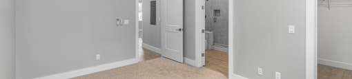 A room with a ceiling fan and a doorway leading to another room.
