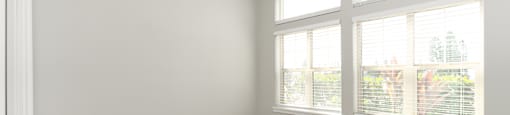 A room with a window and an air conditioner on the wall.