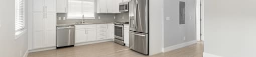 A modern kitchen with stainless steel appliances and white cabinets.
