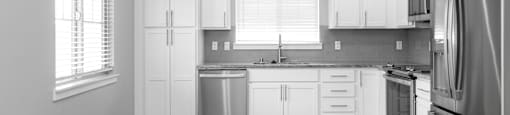 A kitchen with white cabinets and stainless steel appliances.