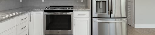 A modern kitchen with white cabinets and stainless steel appliances.