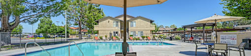 our apartments have a swimming pool and a patio with a table and chairs