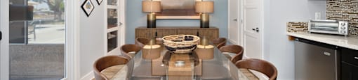 a dining room with a glass table and chairs