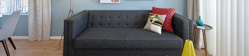 a living room with blue walls and a black couch