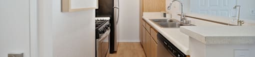 a kitchen with wooden cabinets and a sink and a refrigerator
