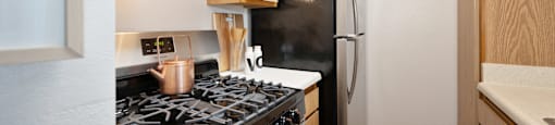 a kitchen with a stove and refrigerator and wooden cabinets